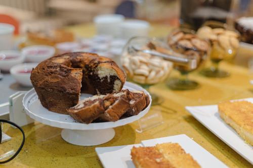 a table topped with a plate of bread and pastries at Hotel Caiuá Lago Umuarama in Umuarama