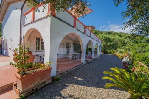 ein Haus mit Bögen und Pflanzen auf einer Straße in der Unterkunft La Palazzina nel Verde - Goelba in Campo nell'Elba