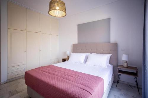 a bedroom with a large bed with a pink blanket at Levante Breeze in Xirokástellon