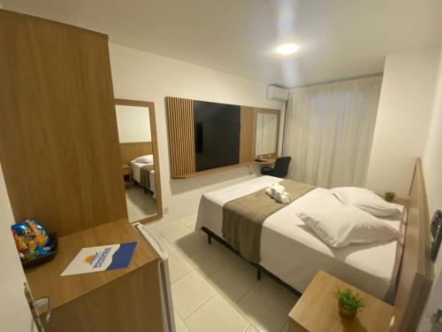 a hotel room with a bed with a teddy bear on it at Pousada Recanto Forte in Florianópolis