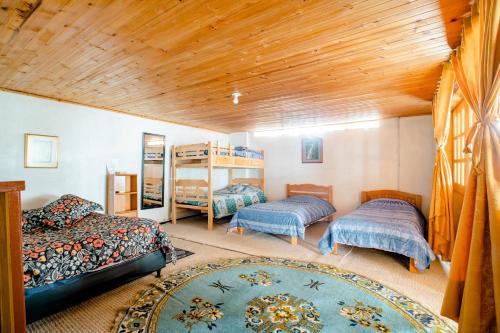 1 dormitorio con 2 camas y techo de madera en El Peregrino, en Cota