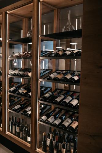 a display case filled with lots of wine bottles at Familienhotel Familiamus in Maranza
