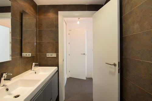 a bathroom with a sink and a white door at Relajante villa, deportes, piscina y vistas a S Nevada in Huétor Santillán