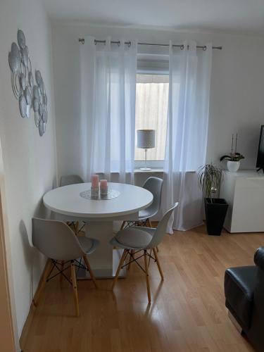 einen weißen Tisch und Stühle im Wohnzimmer in der Unterkunft Sana Ferienwohnung in Oberhausen
