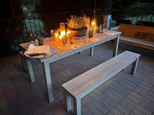 a table with candles and a bench on a patio at Pensjonat Zakątek in Lidzbark