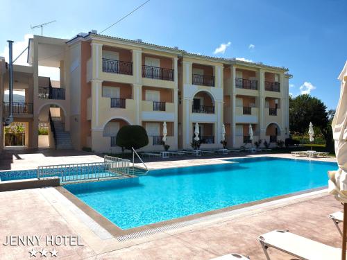 ein Hotel mit einem Pool vor einem Gebäude in der Unterkunft Jenny Hotel in Laganas