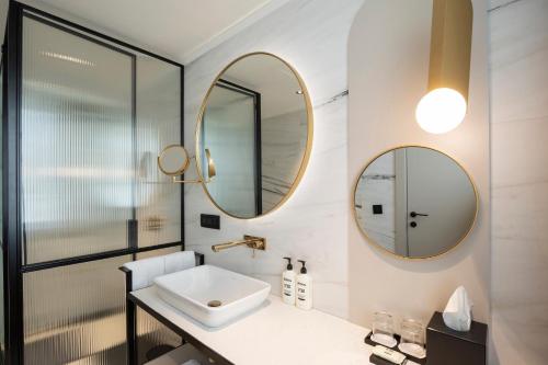 a bathroom with a sink and two mirrors at Hotel Indigo Belgrade by IHG in Belgrade
