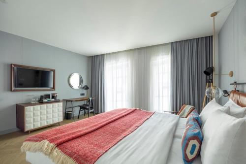 a hotel room with a bed and a television at Hotel Indigo Belgrade by IHG in Belgrade