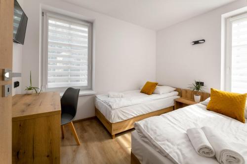 クドヴァ・ズドゥルイにあるApartament Centrum Bの白い部屋で、ベッド2台、デスク、デスクが備わります。