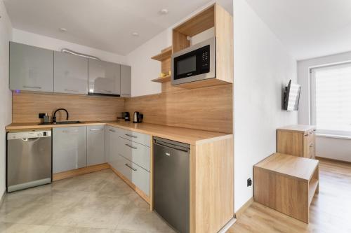 クドヴァ・ズドゥルイにあるApartament Centrum Bの白と木のキャビネット、シンク付きのキッチンが備わります。