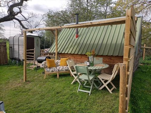 a patio with a table and chairs and a shed at Down The Rabbit Hole in Waterfall