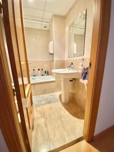 uma casa de banho com um lavatório e um espelho em RoNi RoOms em Salou
