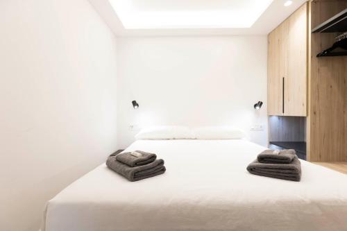 um quarto com uma cama branca e toalhas em Arroka em Hondarribia