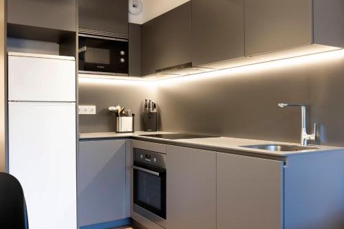 a kitchen with a white refrigerator and a sink at Arroka in Hondarribia