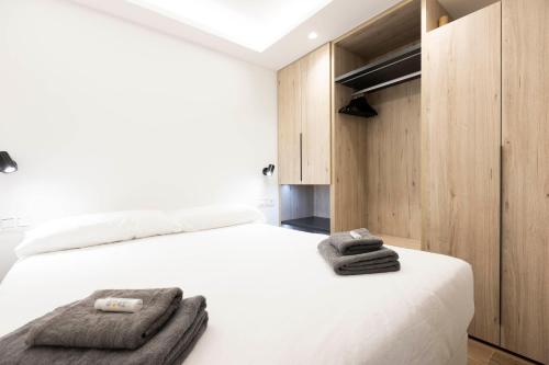 a bedroom with a white bed with towels on it at Arroka in Hondarribia