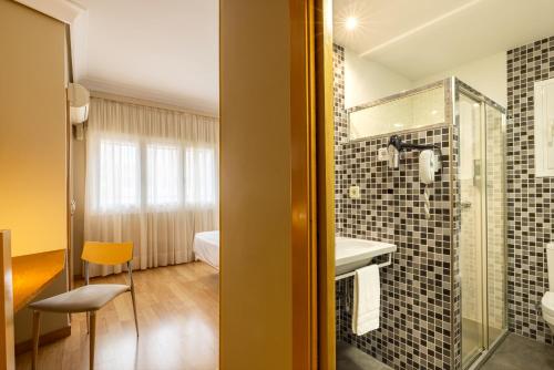 Hotel Santamaria في توذيلا: حمام مع دش ومغسلة ومرآة