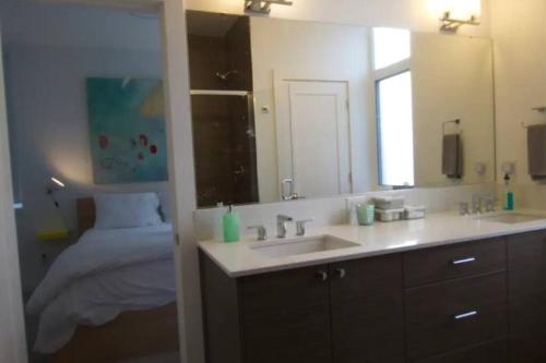 baño con lavabo, espejo y cama en Walkable OTS, Heated Poolside Mid Century Condo en Scottsdale