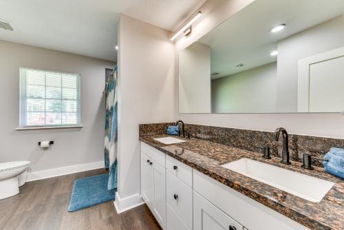 a bathroom with two sinks and a toilet at Luxe Lake Charles Escape with Home Theater! in Lake Charles