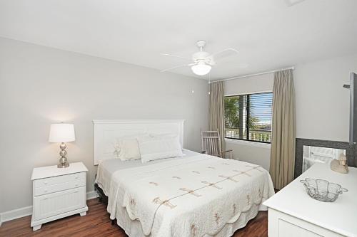 a white bedroom with a white bed and a window at The Sand Dollar at Sea Cloisters in Myrtle Beach