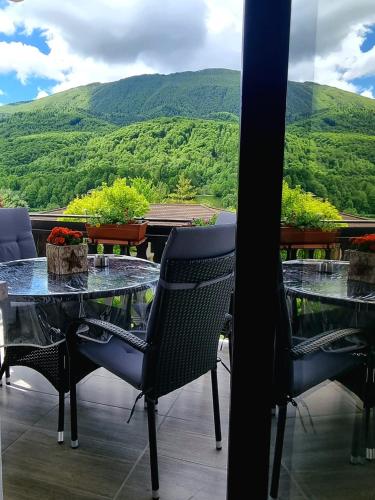 uma mesa e cadeiras com vista para uma montanha em Apartma Vista montana em Kobarid
