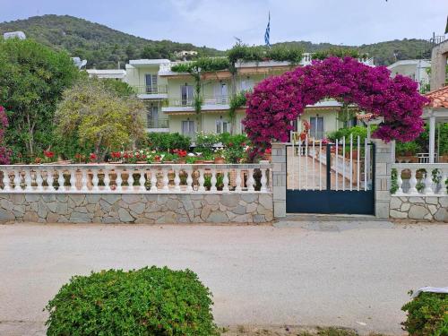 a fence with a gate with purple flowers on it at Rois Appartments in Poros