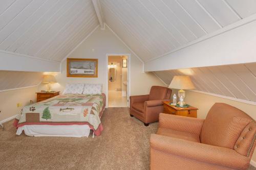 a attic bedroom with a bed and two chairs at Sweetgrass Inn Bed & Breakfast in Rapid City
