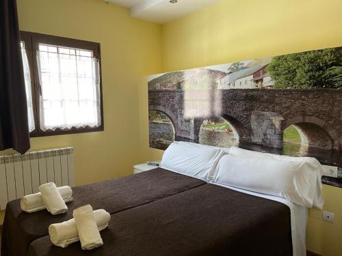 1 dormitorio con 1 cama con 2 toallas en The Way Hotel Molinaseca, en Molinaseca