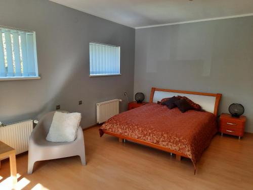 a bedroom with a bed and a chair in it at Medijas in Saulkrasti