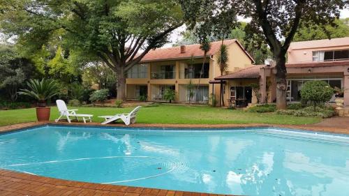 a swimming pool in front of a house at Anka Lodge in Johannesburg