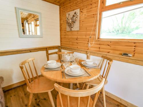 a dining room with a wooden table and chairs at Brook Lodge in Llandysul