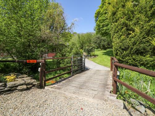 a wooden walkway with a wooden fence and trees at Brook Lodge in Llandysul