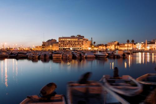 a group of boats docked in a harbor at night at Hotel Made inn Faro in Faro