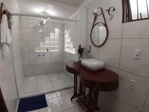 uma casa de banho branca com um lavatório e um chuveiro em Casa Muller 1880 em Nova Petrópolis