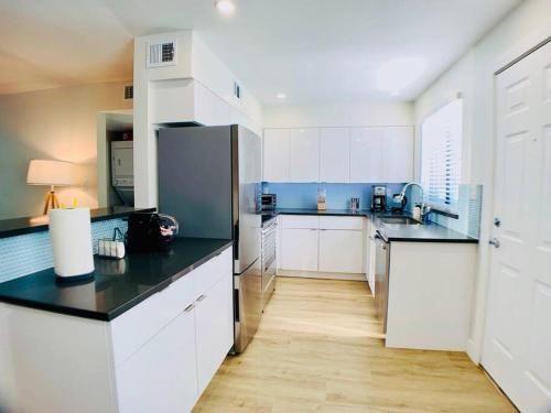 a large kitchen with white cabinets and black counter tops at Primo Old Town Location w/ Heated Pool in Scottsdale