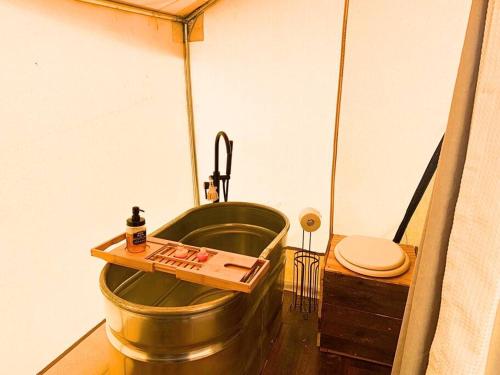 y baño con bañera y aseo. en Silver Spur Homestead Luxury Glamping - The Cowboy, en Tombstone