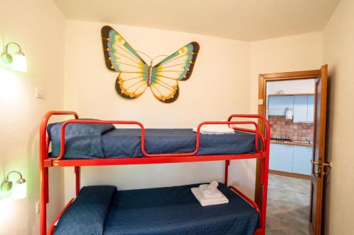 Una habitación con dos literas con una mariposa en la pared. en Domus meravizosas 1, en Posada