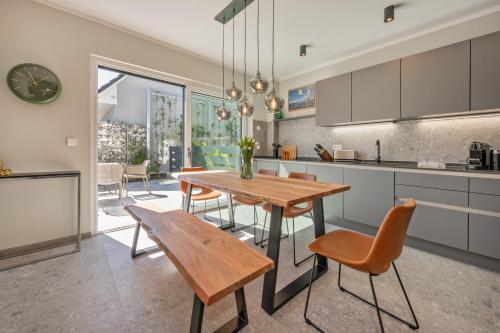 a kitchen and dining room with a wooden table and chairs at Lubminer Meerblick Apartments in Lubmin