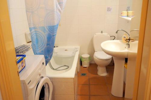 a bathroom with a sink and a toilet and a shower curtain at Sea Front two bedroom House in Lesvos in Tavari