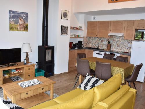 un salon avec un canapé jaune et une cuisine dans l'établissement Appartement Duplex Neuf 4 Pièces avec Balcon, Proche Téléphérique et Centre Aqualudique - FR-1-464-210, à Pralognan-la-Vanoise