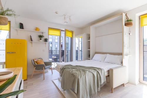 a bedroom with a large bed and a chair at Yellow Studio Paupys in Vilnius