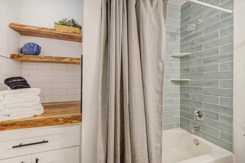 a bathroom with a shower curtain next to a tub at Beachside Retreat Awaits at Jacksonville Beach in Jacksonville Beach