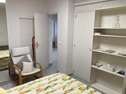 a bedroom with a bed and a chair and shelves at Paseo de la Castellana in Madrid