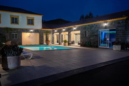 a villa with a swimming pool at night at Quinta da Paz Azores in Pico da Pedra
