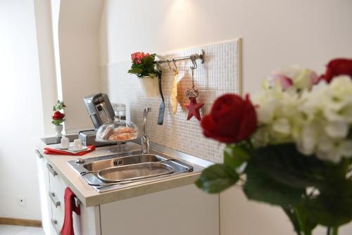 a kitchen with a sink and flowers on the counter at B&B La Dimora di Iside in Benevento