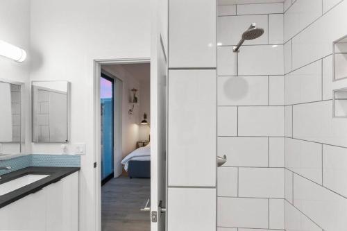 a white bathroom with a shower and a sink at Poolside Studio w Rooftop Deck - Walk to Old Town in Scottsdale
