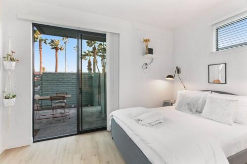 um quarto branco com uma cama e uma varanda em Poolside Studio w Rooftop Deck - Walk to Old Town em Scottsdale