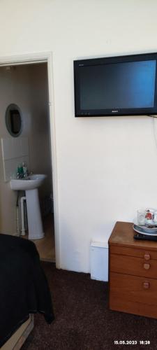 a room with a tv on the wall and a sink at Bright Apartments in Peterborough