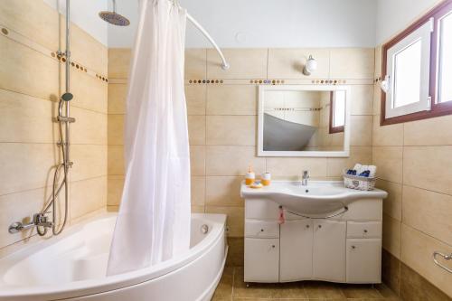 y baño con bañera y lavamanos. en Glyna House, en Skopelos Town