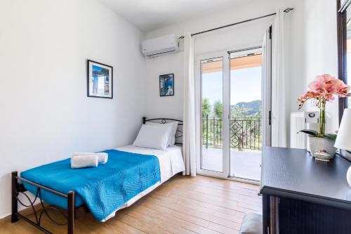a small bedroom with a bed and a balcony at Glyna House in Skopelos Town
