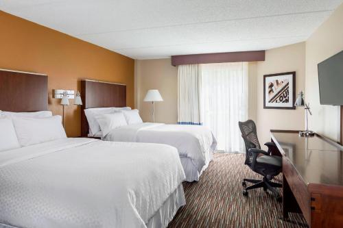 a hotel room with two beds and a desk at Four Points by Sheraton Buffalo Grove in Buffalo Grove